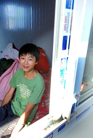 Li Chuncheng smiles as he sits in his temporary plank house at Huilong Village in Qingchuan County, southwest China's Sichuan Province, June 5, 2008. 