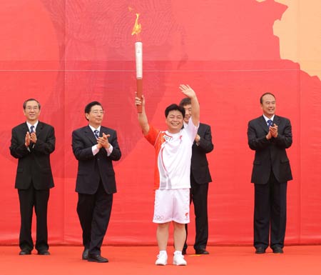 Torchbearer Wu Shude holds up the torch during the launching ceremony of the 2008 Beijing Olympic Games torch relay in Nanning, southwest China's Guangxi Zhuang Autonomous Region, June 7, 2008.