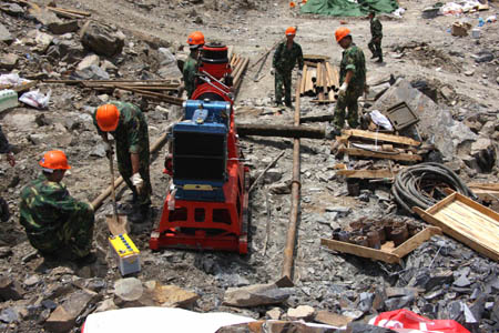 Engineers install a drilling machine at the Tangjiashan quake-formed lake in southwest China's Sichuan Province, May 9, 2008. The drainage plus natural leakage of the lake was about 48 cubic meters per second, a hydro expert said on Monday morning. The Chengdu Military Command of the People's Liberation Army sent an additional 120-strong team to blast boulders in the channel to accelerate drainage.