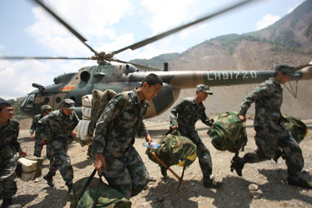 Soldiers of the additional team arrive at the Tangjiashan quake-formed lake in southwest China's Sichuan Province, May 9, 2008. The drainage plus natural leakage of the lake was about 48 cubic meters per second, a hydro expert said on Monday morning. The Chengdu Military Command of the People's Liberation Army sent an additional 120-strong team to blast boulders in the channel to accelerate drainage.