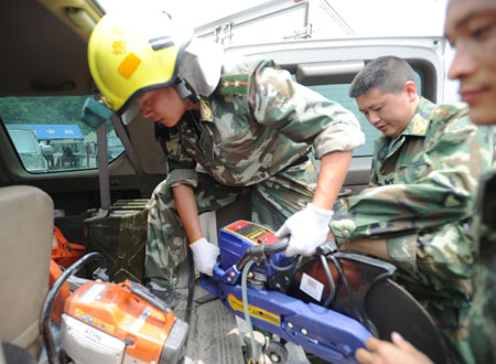 Soldiers carry machines onto a vehical before they set off to the spot where remains of the missing Chinese helicopter were found at Yingxiu Township, Wenchuan County in Southwest China's Sichuan Province on June 10, 2008. 