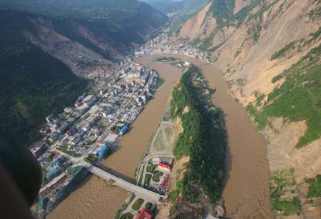Picture taken on June 10, 2008 from a military helicopter shows flood water flowing past Beichuan County in southewest China's Sichuan Province. Drainage of the Tangjiashan quake lake through a manmade spillway speeded up to 1,760 cubic meters per second at 9:30 am on Tuesday, whereas water flow in the lower reaches of the lake, in Beichuan County, reached 2,240 cubic meters per second. (Xinhua/Li Gang)