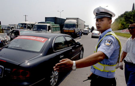 Traffic police directs the traffic along the bank of the Fujiang River in Mianyang city,southewest China's Sichuan Province, June 10,2008.