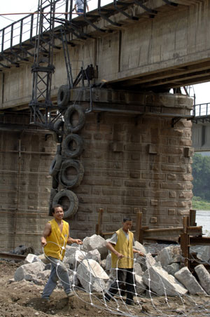 Workers are busy in the protection of Fujiang Bridge on the railway from Baoji, a city of northwest China’s Shaanxi Province, to Chengdu, in Mianyang city, southwest China's Sichuan Province, June 10, 2008. 