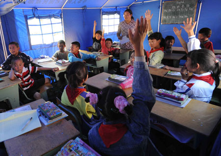 Volunteer Guang Hushan organizes children to select a monitor in a tent school in Shidaguan Township of Maoxian County, southwest China's Sichuan Province, June 10. A tent school was built in the help of the People's Liberation Army and completed its construction on June 8.