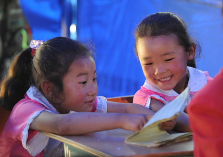 Yang Siyu (L), and Yang Silu, who are sisters of Qiang ethnic group, study in a tent school in Shidaguan Township of Maoxian County, southwest China's Sichuan Province, June 10. A tent school was built with the help of the People's Liberation Army and completed its construction on June 8. Teachers consisted of soldiers graduated from universities and local volunteers. Thus, children living nearby are able to continue their study after the May 12 quake.