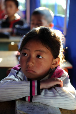 Yang Xue, a 7-year-old girl, listens at a class in a tent school in Shidaguan Township of Maoxian County, southwest China's Sichuan Province, June 10. 