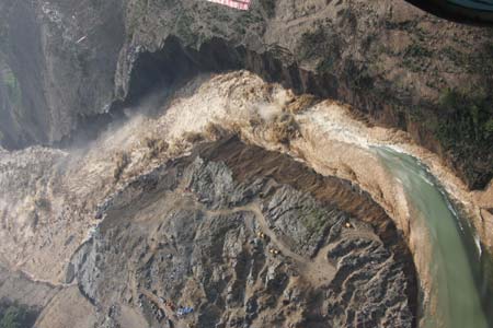 Picture taken at 9 a.m. of June 10, 2008 from a military helicopter shows the water gushed out of the Tangjiashan quake lake in southewest China's Sichuan Province. Drainage of the quake lake through a manmade spillway speeded up to 1,760 cubic meters per second at 9:30 am on Tuesday, whereas water flow in the lower reaches of the lake, in Beichuan County, reached 2,240 cubic meters per second. (Xinhua/Li Gang)