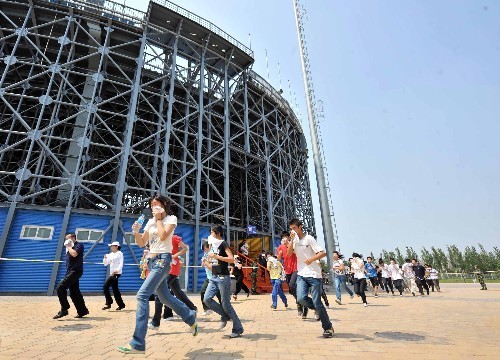 'Spectators' are evacuated from the beach volleyball venue in Chaoyang Park during an Olympic security drill in Beijing on Wednesday, June 11, 2008. 