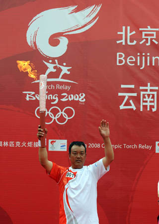 Torchbearer Ma Bajin of the Tibetan ethnic group displays the torch at the launching ceremony of the 2008 Beijing Olympic Games torch relay in Xamgyi&apos;nyilha, southwest China&apos;s Yunnan Province on June 11, 2008.
