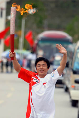 Torchbearer Chen Jianli, photographer from China&apos;s Xinhua News Agency,runs during the 2008 Beijing Olympic Games torch relay in Xamgyi&apos;nyilha, southwest China&apos;s Yunnan Province on June 11, 2008. 