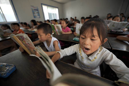 Second graders attend class in a temporary classroom at Chengguan No.2 elementary school in Wenxian county, Longnan city, northwest China's Gansu Province June 11, 2008. About 90 percent of the 2,964 middle schools and elementary schools suspended in the quake-hit Longnan city have resumed classes by now. The local government is still working hard to help reopen schools and kindergartens in remote villages and mountainous areas.