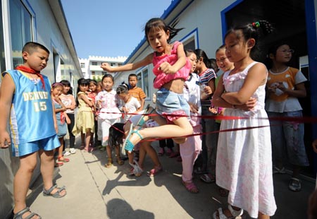Third graders play games during a break at Chengguan No.2 elementary school in Wenxian county, Longnan city, northwest China's Gansu Province June 11, 2008. About 90 percent of the 2,964 middle schools and elementary schools suspended in the quake-hit Longnan city have resumed classes by now. The local government is still working hard to help reopen schools and kindergartens in remote villages and mountainous areas. 