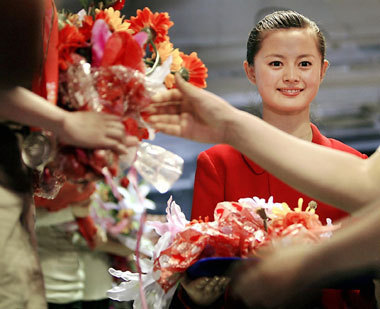 A volunteer holds flowers during a training session for Olympic victory ceremony volunteers in Beijing yesterday. 
