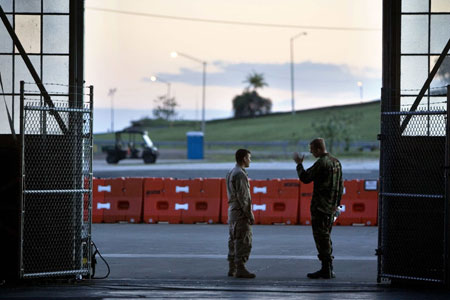 In this image reviewed by the U.S. Military, two soldiers talk at dawn at the entrance to a hangar at Guantanamo Bay U.S. Naval Base in Cuba June 6, 2008. U.S. Supreme Court ruled on Thursday that foreign terrorism prisoners held in U.S. Navy base in Guantanamo, Cuba, can challenge their detention in U.S. civilian courts. 
