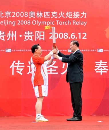 Torchbearer Ouyang Ziyuan (L), academician of the Chinese Academy of Sciences (CAS) and chief scientist of the lunar exploration program receives the torch from Shi Zongyuan, secretary of the Guizhou Provincial Committee of the Communist Party of China (CPC) at the launching ceremony of the 2008 Beijing Olympic Games torch relay in Guiyang, capital of southwest China's Guizhou Province on June 12, 2008. 