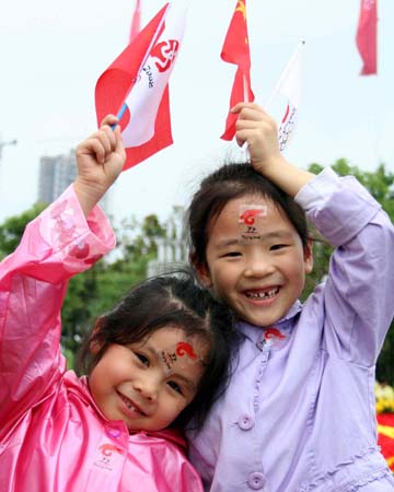 Two little girls cheer for the 2008 Beijing Olympic Games torch relay in Guiyang, capital of southwest China's Guizhou Province on June 12, 2008. 