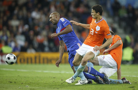 France's Nicolas Anelka (L) is tackled by two 