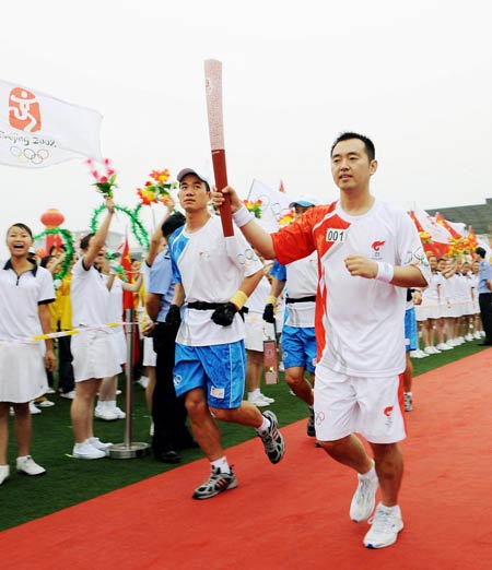 Photo: First torchbearer Kong Linghui runs with the torch