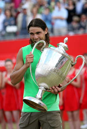 Spanish Rafael Nadal bites the trophy after winning the final of the Artois Championship tennis tournament against Serbian Novak Djokovic at Queen's Club in west London on June 15, 2008. Nadal won 7-6(6), 7-5.(Xinhua/Xie Xiudong) 