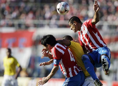 Paraguay's Paulo da Silva (R) and Denis Caniza (4) jump for the ball during their World Cup 2010 qualifying soccer match in Asuncion June 15, 2008.  