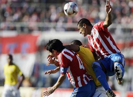 Paraguay's Paulo da Silva (R) and Denis Caniza (4) jump for the ball during their World Cup 2010 qualifying soccer match in Asuncion June 15, 2008. 