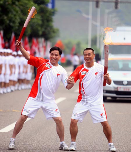 Photo: Two torchbearers pose to celebrate after handing-over the Olympic flame