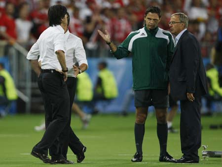 Germany's coach Joachim Loew (L) and Austria's coach Josef Hickersberger (R) speak with the fourth match official (2ndR) during the Group B Euro 2008 soccer match between Austria and Germany at the Ernst Happel Stadium in Vienna, June 16, 2008. (Xinhua/Reuters Photo)