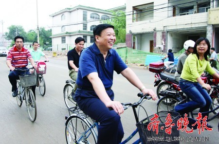 Jiang Daming (C), governor of Shandong Province, rides a bicycle to work in Jinan on June 16, 2008. [Photo: qlwb.com.cn]