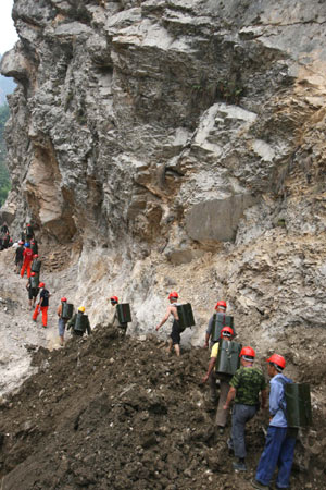 - Photo taken on June 6, 2008 shows locals transport buckets of fuel for construction machines used for repairing a road linking towns of Suishui and Gaochuan in Anxian County of quake-hit Sichuan Province, southwest China. 