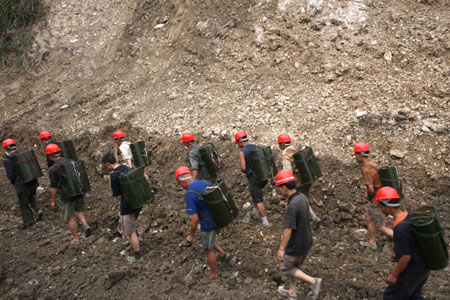  Photo taken on June 6, 2008 shows locals transport buckets of fuel for construction machines used for repairing a road linking towns of Suishui and Gaochuan in Anxian County of quake-hit Sichuan Province, southwest China. 