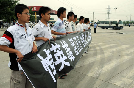  Local people hold banner to bid farewell to Zhang Peng, a crew member of the crashed helicopter on a quake relief mission on May 31, in Tengzhou City, east China's Shandong Province, June 17, 2008. 
