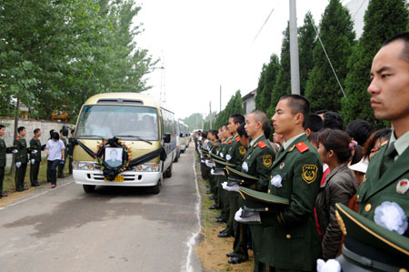 Armed policemen stand along the road side to bid farewell to Zhang Peng, a crew member of the crashed helicopter on a quake relief mission on May 31, in Tengzhou City, east China's Shandong Province, June 17, 2008. 