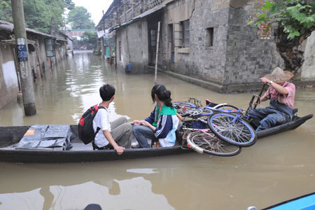 Residents row boats in a flooded street in Pingyao Town of Hangzhou City, East China&apos;s Zhejiang Province, June 18, 2008. Rainstorms and floods have hit the provinces of Zhejiang, Anhui, Jiangxi, Hubei, Hunan, Guangdong, Guizhou and Yunnan and the Guangxi Zhuang Autonomous Region since June 6. [Xinhua]