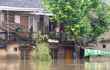 A resident stands on the balcony of a flooded house in Pingyao Town of Hangzhou City, East China&apos;s Zhejiang Province, June 18, 2008. Rainstorms and floods have hit the provinces of Zhejiang, Anhui, Jiangxi, Hubei, Hunan, Guangdong, Guizhou and Yunnan and the Guangxi Zhuang Autonomous Region since June 6. [Xinhua]