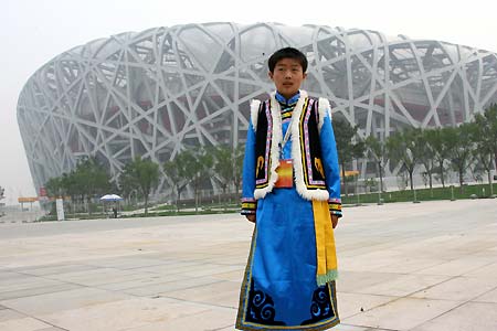 14-year-old Li Pan, from the Qiang ethnic minority, poses in front of the National Stadium, or 'Bird's Nest', June 19, 2008. Fifty-six ambassadors of China's 56 ethnic groups, most with a physical disability, will enjoy the host city in a five-day 'Olympic Tour' event until June 23.