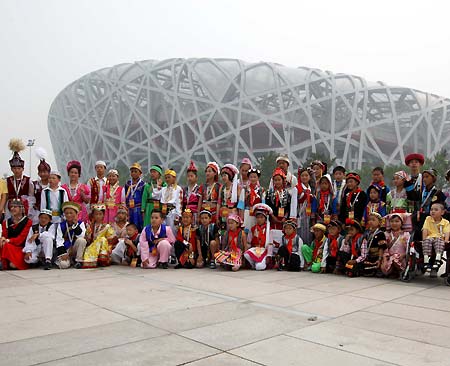Boys and girls, representing China's 56 ethnic groups, pose in front of the National Stadium, or 'Bird's Nest', June 19, 2008. These 56 ambassadors of China's 56 ethnic groups, most with a physical disability, will enjoy the host city in a five-day 'Olympic Tour' event until June 23. 