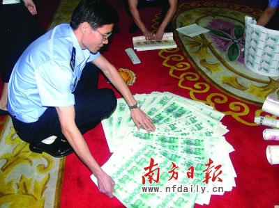 A policeman shows semi-finished 50 yuan counterfeit notes in this photo published on Friday, June 20, 2008. [Photo: nfdaily.cn]