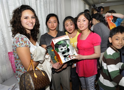 Olympic homestay family members send a Fuwa to an American volunteer as gift in Qingdao on Friday, June 20, 2008. [Photo: Xinhua]