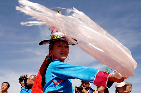 A local dancer performs an ethnic dance during the Beijing Olympic torch relay along Qinghai Lake, the largest inland saltwater lake in China, June 23, 2008. Half of the 162 torchbearers are Tibetans.