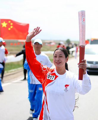 A Tibetan torchbearer runs with the Beijing Olympic torch during its relay along Qinghai Lake, the largest inland saltwater lake in China, June 23, 2008. Half of the 162 torchbearers are Tibetans. 
