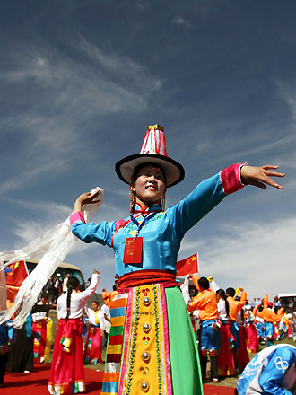 A local dancer performs an ethnic dance during the Beijing Olympic torch relay along Qinghai Lake, the largest inland saltwater lake in China, June 23, 2008. Half of the 162 torchbearers are Tibetans. 