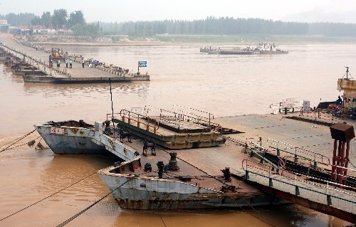 Workers remove the Luokou floating bridge over Yellow River in Jinan, east China's Shandong Province on June 22. [Photo: Xinhua]