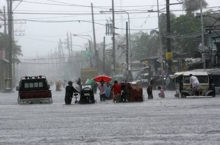 Residents wade through knee-deep floodwaters after a Typhoon Fengshen pelted metro Manila with torrential rain and high winds June 22, 2008. [Photo: Xinhua/Reuters]