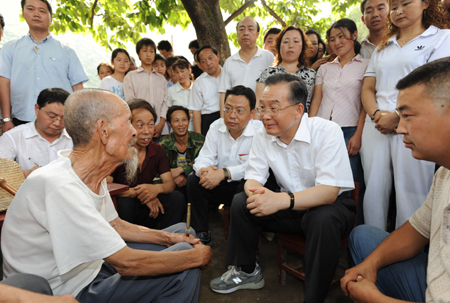 Chinese Premier Wen Jiabao talks to an elderly man during his visit to the badly-hit Lueyang County in Shaanxi Province Friday, June 20, 2008.