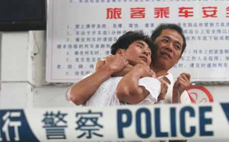 A criminal suspect(R) kidnapped a passenger with explosive during an anti-terrorist exercise at the Huaibei railway station in Huaibei City, east China's Anhui Province, June 21, 2008.(