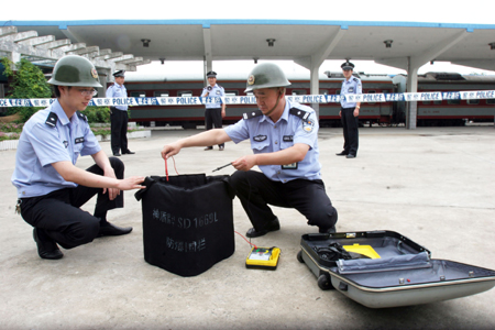 Blasting experts dispose suspicious explosive during an anti-terrorist exercise at the Huaibei railway station in Huaibei City, east China's Anhui Province, June 21, 2008.