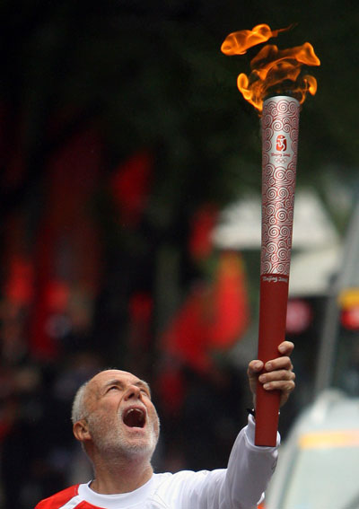 Photo: Torchbearer F. A. Hutchison from the US runs with torch