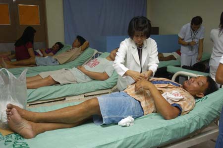 Medical personnel attend to survivors of the passenger ferry MV Princess of Stars after it capsized off Sibuyan island, central Philippines, at a hospital in Lucena city south of Manila June 23, 2008. Rescuers held little hope on Monday of finding some 800 people missing from the ferry, as divers prepared to drill into the ship's hull in the hope of finding survivors in air pockets.