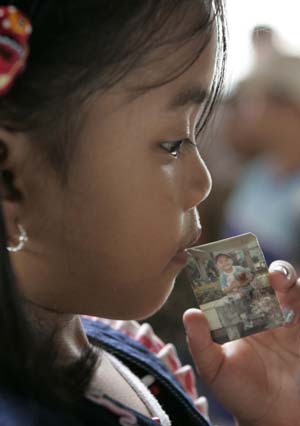 Alaysa Caranoo holds a photo of her brother, who was on board the capsized ferry MV Princess of Stars, while waiting with relatives for the latest information outside the office of Sulpicio Lines in the port area of Manila June 23, 2008. Rescuers scoured the seas around the capsized ferry in the Philippines on Monday for more than 800 people missing after it sank two days ago, as the official death toll from Typhoon Fengshen rose to about 160.